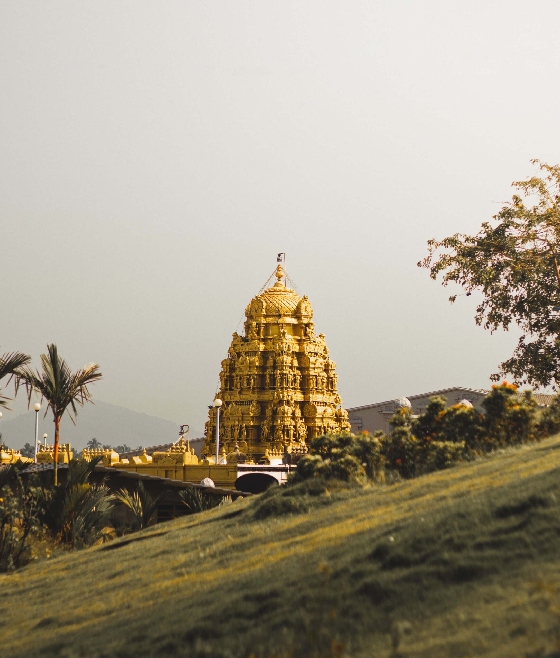 A stunning view of the golden temple in Murdeshwar, Karnataka, surrounded by lush greenery.