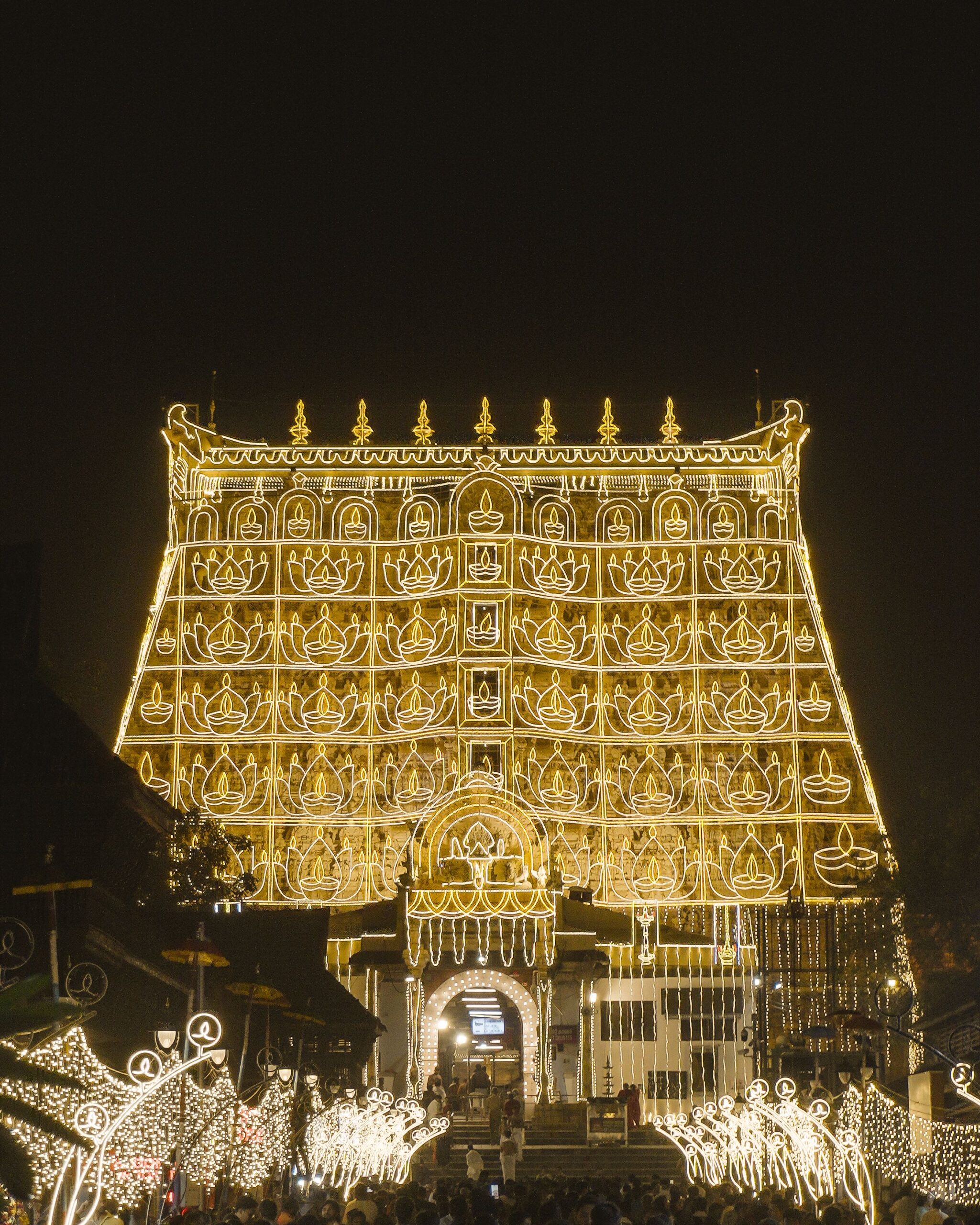 The Padmanabhaswamy Temple dazzling at night with traditional Indian lighting displays.